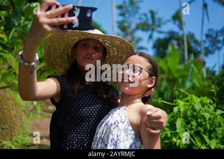 Deux adorables adolescentes qui prennent des selfies ensemble en se posant bien devant l'appareil photo Banque D'Images