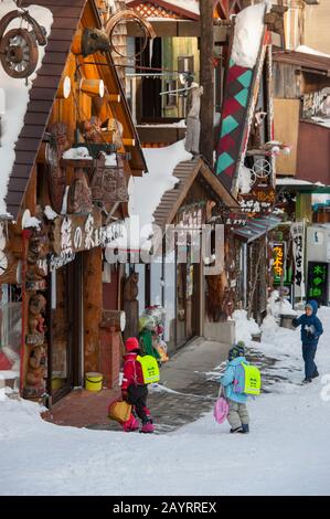 Scène de rue avec des enfants de l'école locale à Ainu Kotanan, qui est un petit village Ainu à Akankohan, parc national Akan, Hokkaido, Japon. Banque D'Images