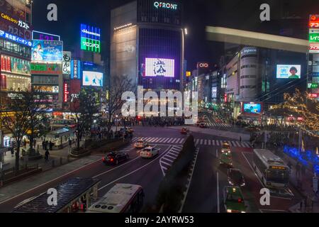 Vue la nuit de l'intersection à l'extérieur de la gare de Shibuya avec des piétons traversant de tous les côtés à Tokyo, Japon. Banque D'Images