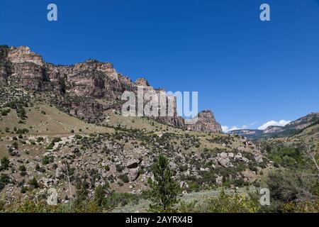 Le magnifique paysage de Ten Sleep Canyon sur la route 16 au Wyoming avec de grandes falaises de roches vertes brosse et arbres et un ciel bleu clair. Banque D'Images