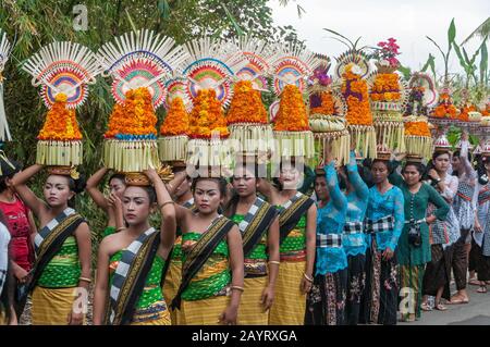 Bali, Indonésie - 26 juillet 2010: Groupe de femmes en costumes traditionnels et offre colorée sur leur tête marcher jusqu'au temple Saint Pura Tanah Lot. Banque D'Images