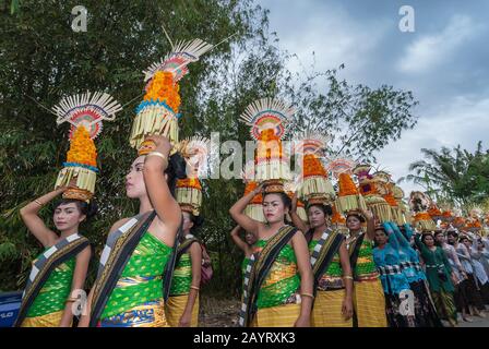 Bali, Indonésie - 26 juillet 2010: Groupe de femmes en costumes traditionnels et offre colorée sur leur tête marcher jusqu'au temple Saint Pura Tanah Lot. Banque D'Images