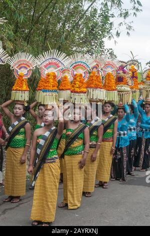 Bali, Indonésie - 26 juillet 2010: Groupe de femmes en costumes traditionnels et offre colorée sur leur tête marcher jusqu'au temple Saint Pura Tanah Lot. Banque D'Images