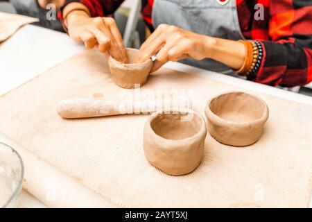 Les jeunes amis de femmes créent des plats d'art en argile et céramique dans l'atelier de poterie Banque D'Images