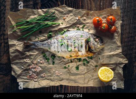 Rame de mer à tête dorée (Sparus aurata) cuite au four avec du citron, de la ciboulette et du sel. Banque D'Images