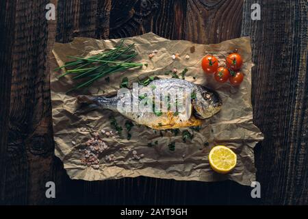 Rame de mer à tête dorée (Sparus aurata) cuite au four avec du citron, de la ciboulette et du sel. Banque D'Images