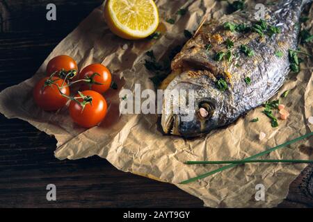 Rame de mer à tête dorée (Sparus aurata) cuite au four avec du citron, de la ciboulette et du sel. Banque D'Images