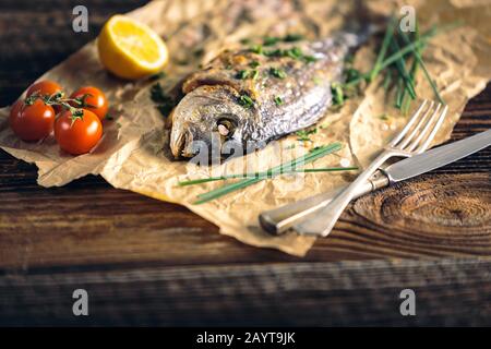 Rame de mer à tête dorée (Sparus aurata) cuite au four avec du citron, de la ciboulette et du sel. Banque D'Images