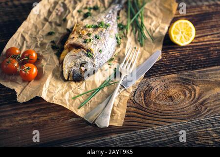 Rame de mer à tête dorée (Sparus aurata) cuite au four avec du citron, de la ciboulette et du sel. Banque D'Images