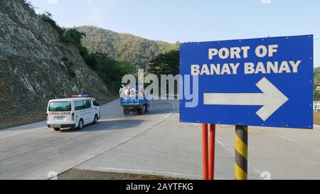 Banay Banay, Davao Oriental, Philippines - Mars 2016: Panneau de signalisation routière avec direction du port de Banay Banay avec un camion et une ambulance trave Banque D'Images