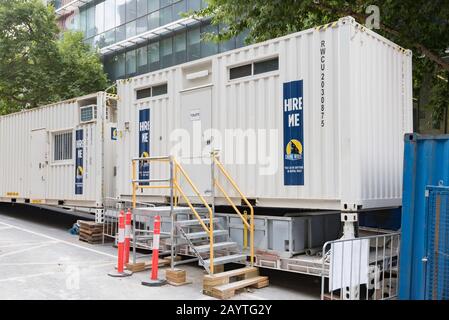 Conteneurs d'expédition convertis en hangars de l'ouvrier et un bloc de toilettes avec un réservoir de stockage des déchets sur un lieu de travail à Lonsdale Street, Melbourne. Banque D'Images