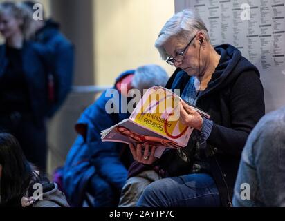 Berlin, Allemagne. 17 février 2020. Une femme est assise à la Potsdamer Platz Arkaden, en lisant le programme Berlinale, en attendant le début de la vente de billets pour le Festival International du Film "Berlinale". Crédit: Paul Zinken/Dpa/Alay Live News Banque D'Images