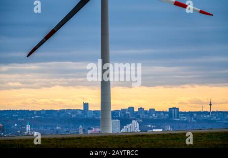 Walker sur le tas de scories de Hoheward à Herten, centrale éolienne sur le tas de scories de Hoppenbruch, vue sur les gratte-ciel d'Essen, NRW, Allemagne Banque D'Images