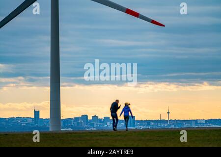 Walker sur le tas de scories de Hoheward à Herten, centrale éolienne sur le tas de scories de Hoppenbruch, vue sur les gratte-ciel d'Essen, NRW, Allemagne Banque D'Images