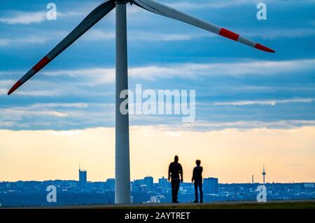 Walker sur le tas de scories de Hoheward à Herten, centrale éolienne sur le tas de scories de Hoppenbruch, vue sur les gratte-ciel d'Essen, NRW, Allemagne Banque D'Images