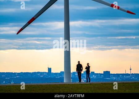 Walker sur le tas de scories de Hoheward à Herten, centrale éolienne sur le tas de scories de Hoppenbruch, vue sur les gratte-ciel d'Essen, NRW, Allemagne Banque D'Images