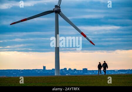 Walker sur le tas de scories de Hoheward à Herten, centrale éolienne sur le tas de scories de Hoppenbruch, vue sur les gratte-ciel d'Essen, NRW, Allemagne Banque D'Images