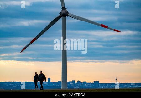 Walker sur le tas de scories de Hoheward à Herten, centrale éolienne sur le tas de scories de Hoppenbruch, vue sur les gratte-ciel d'Essen, NRW, Allemagne Banque D'Images