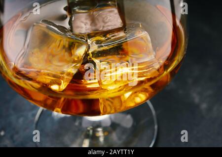 table en béton, glace froide, glaçons, whisky bourbon, scotch whisky, verre à injection Banque D'Images
