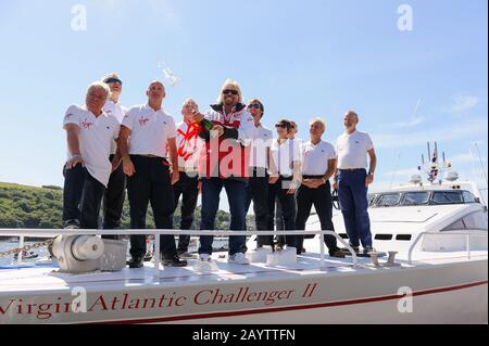 Sir Richard Branson coupe le champagne avec l'équipage original et nouveau du Challenger II Virgin Atlantic lors d'une réunion à Fowey. Banque D'Images