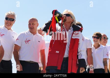 Sir Richard Branson coupe le champagne avec l'équipage original et nouveau du Challenger II Virgin Atlantic lors d'une réunion à Fowey. Banque D'Images