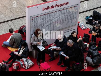 Berlin, Allemagne. 17 février 2020. Les amoureux du film attendent dans la Potsdamer Platz Arkaden à côté d'un conseil d'administration avec les mots « Berlinale Program » pour le début des ventes de billets à l'avance pour le « Berlinale » International Film Festival. Crédit: Paul Zinken/Dpa/Alay Live News Banque D'Images