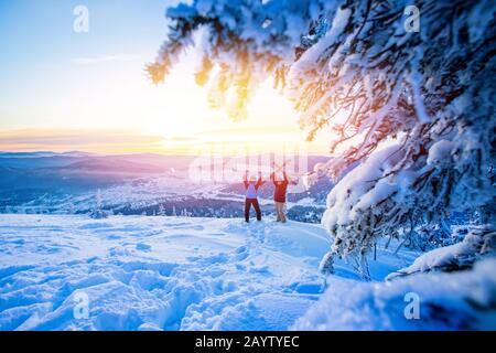 Deux amis actifs snowboarder et skieur debout sur le toit de montagne bleu ciel lever. Concept station de ski forêt d'hiver Banque D'Images