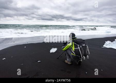 Photographe prenant des photos sur Diamond Beach, près du lagon de Jokulsarlon, Islande. Photographie de paysage Banque D'Images