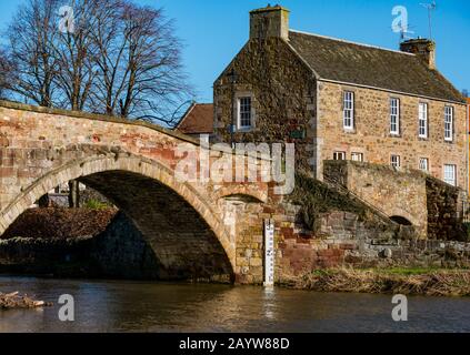 River Tyne, Haddington, East Lothian, Écosse, Royaume-Uni, 17 Février 2020. Royaume-Uni Météo: Le soleil brille sur la rive du pont Nungate avec le niveau d'eau après de récentes fortes pluies indiquées par le marqueur d'inondation Banque D'Images