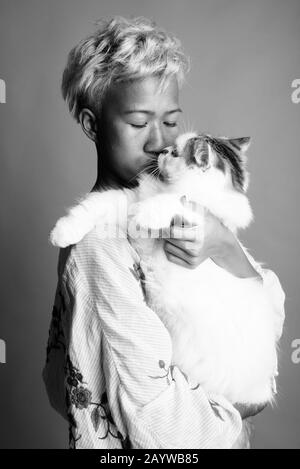 Jeune belle femme rebelle avec des cheveux courts sur fond gris Banque D'Images