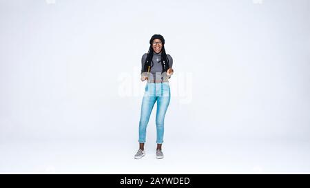 Une femme africaine excitée qui a de longs readlocks regardant la caméra. Femme africaine souriante isolée sur fond blanc. Banque D'Images