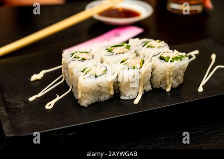 Véritable sushi japonais dans un restaurant à Tokyo. Jeu de sushi sur une plaque noire en pierre Banque D'Images