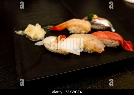 Véritable sushi japonais dans un restaurant à Tokyo. Jeu de sushi sur une plaque noire en pierre Banque D'Images