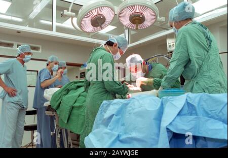 le personnel du théâtre hospitalier, y compris le chirurgien, l’infirmière en services de nettoyage et l’anesthésiste, effectue une opération. Banque D'Images