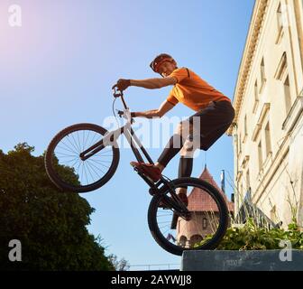 Cliché à angle bas d'un vélo d'essai debout sur une roue arrière de VTT en gardant l'équilibre en regardant la caméra, le concept de mode de vie actif Banque D'Images