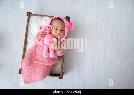 Vue de dessus sur un bébé nouveau-né avec son jouet en peluche dans les mains Banque D'Images