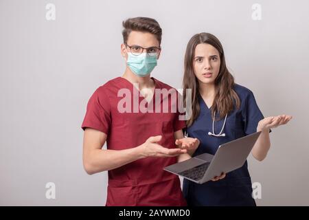 deux jeunes médecins avec ordinateur portable isolé sur blanc Banque D'Images