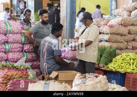 Dambulla, Sri Lanka: 18/03/2019: Marché intérieur de la vente de fruits et légumes. Les hommes négociant les prix pour les produits. Banque D'Images