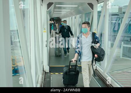 Hong Kong, Chine. 14 février 2020. Les passagers portent des masques chirurgicaux sur un pont d'accès à l'avion à l'aéroport international de Hong Kong.À Mesure Que le nombre de victimes du nouveau Coronavirus augmente, de plus en plus de pays annulent les vols à l'intérieur et à l'extérieur de la région. Crédit: Sopa Images Limited/Alay Live News Banque D'Images