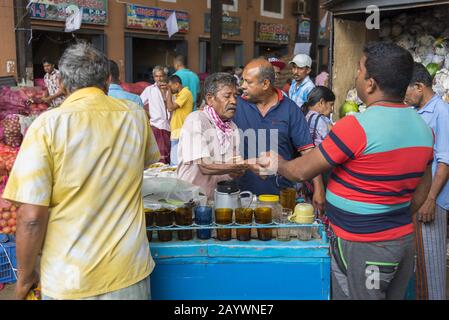 Dambulla, Sri Lanka: 18/03/2019: Marché intérieur de la vente de fruits et légumes. Hommes vendant des rafraîchissements, du thé, du café. Banque D'Images