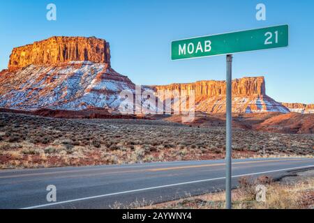 Moab 33,5 km panneau de route près de Casttle Valley dans l'Utah, paysage d'hiver au lever du soleil - concept de voyage et de loisirs Banque D'Images