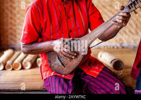 Un Homme Du Groupe Ethnique De Kayah Jouant Une Guitare Comme Instrument, Hta Nee La Leh Village, Loikaw, Kayah State, Myanmar. Banque D'Images