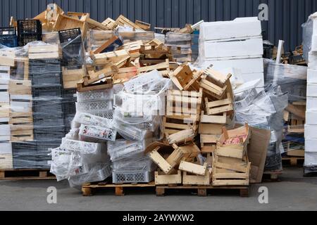 Piles de boîtes en bois et en plastique à l'entrepôt dans la cour du magasin. Boîtes et conteneurs utilisés pour le transport de produits par camion. Fret et expédition à s Banque D'Images