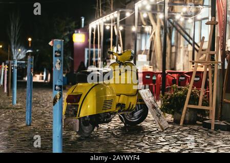 Scooter jaune de couleur vive garé dans une rue Banque D'Images