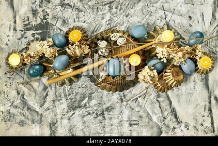 Bannière de Pâques : composition à partir d'œufs bleus, formes de gâteau, branches d'arbres, fleurs sèches et bougies sur fond de béton, espace de copie, religieux chrétien Banque D'Images