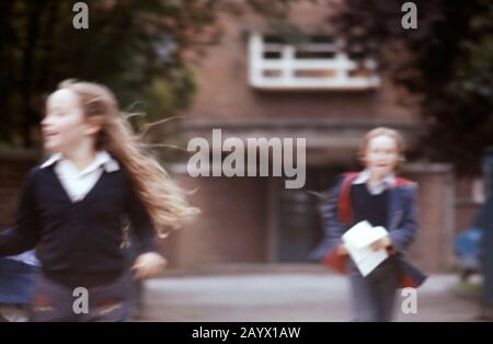 Un jeune frère et une sœur sortant de l'école à la fin de la journée, Royaume-Uni 1973 Banque D'Images