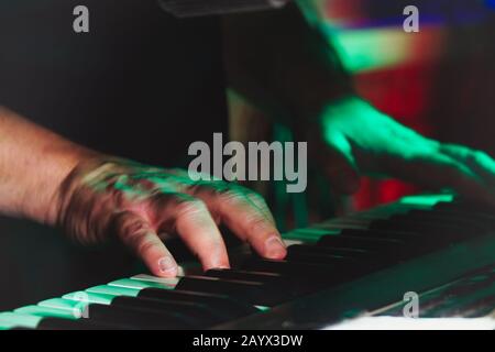 Mains d'UN pianiste ou d'un claviériste d'un groupe rock en gros plan jouant à un synthétiseur. Mise au point sélective Banque D'Images