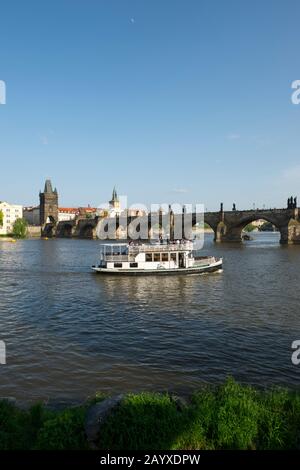 Bateau d'excursion sur la Vltava avec le pont Charles en arrière-plan à Prague, la capitale et la plus grande ville de la République tchèque. Banque D'Images