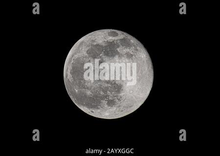 Grande lune dans sa phase complète avec des cratères détaillés visibles sur ses bords, le tout dans un fond noir Banque D'Images
