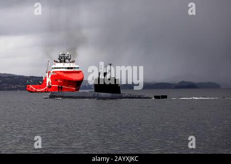 Sous-marin norvégien KNM Uredd S305 de la classe Ula, au départ du port de Bergen, Norvège. En arrière-plan, l'approvisionnement en tapis de manutention d'ancrage AHTS offshore ve Banque D'Images